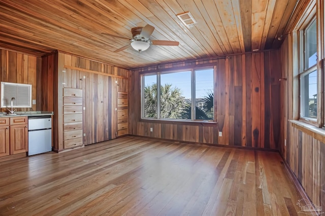 kitchen featuring fridge, plenty of natural light, light wood-style floors, and a sink