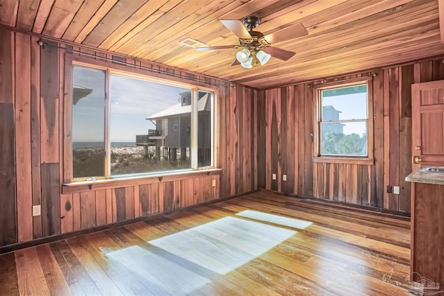 spare room with wood ceiling, plenty of natural light, and wood finished floors