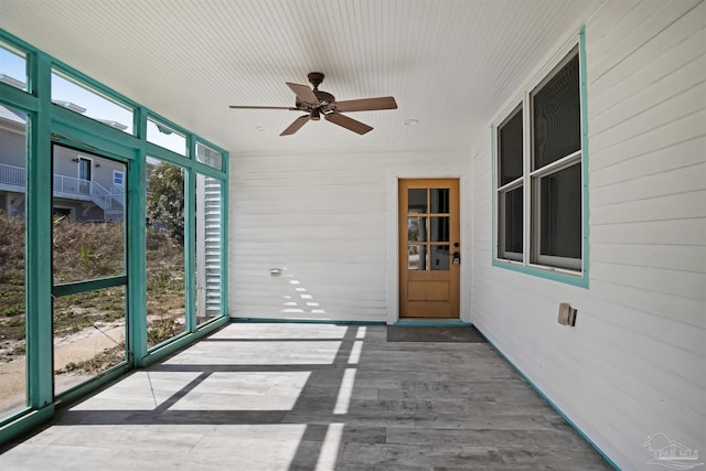 unfurnished sunroom with a ceiling fan