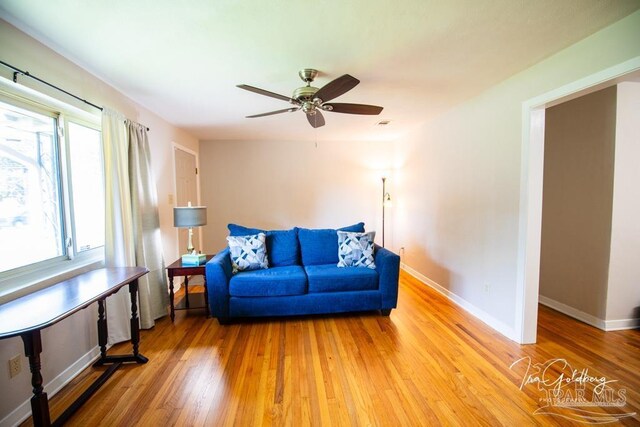 living room with light wood-type flooring and ceiling fan