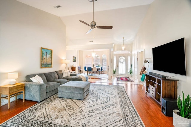 living room with dark hardwood / wood-style flooring, high vaulted ceiling, and ceiling fan