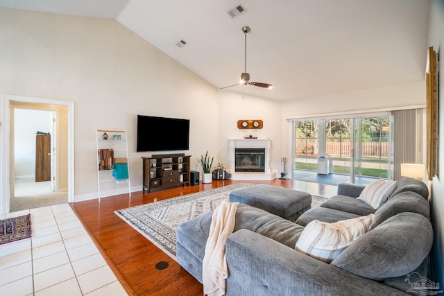 living room featuring hardwood / wood-style floors, high vaulted ceiling, and ceiling fan