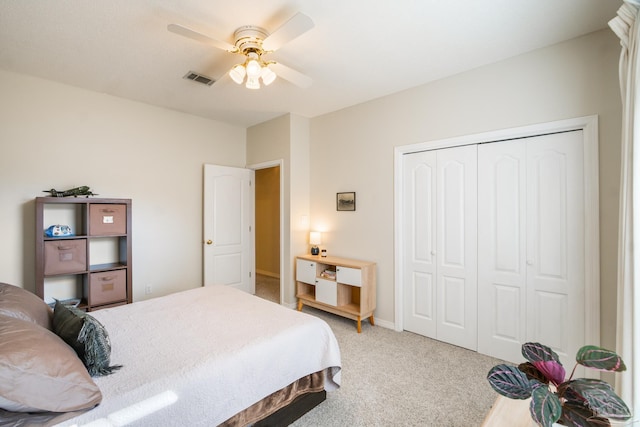 bedroom with ceiling fan, light colored carpet, and a closet