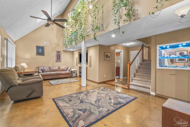 tiled living room featuring ceiling fan, high vaulted ceiling, and a textured ceiling