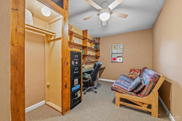 office area with ceiling fan, carpet flooring, and a textured ceiling