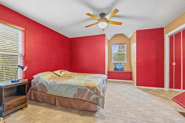 bedroom with light carpet, a textured ceiling, lofted ceiling, and ceiling fan