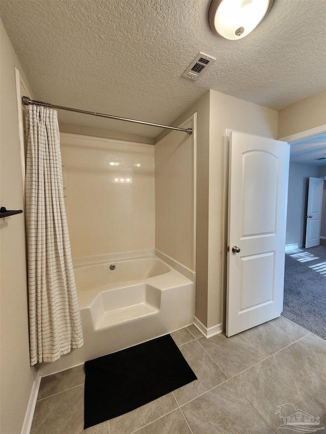 bathroom with a textured ceiling, tile patterned floors, and independent shower and bath