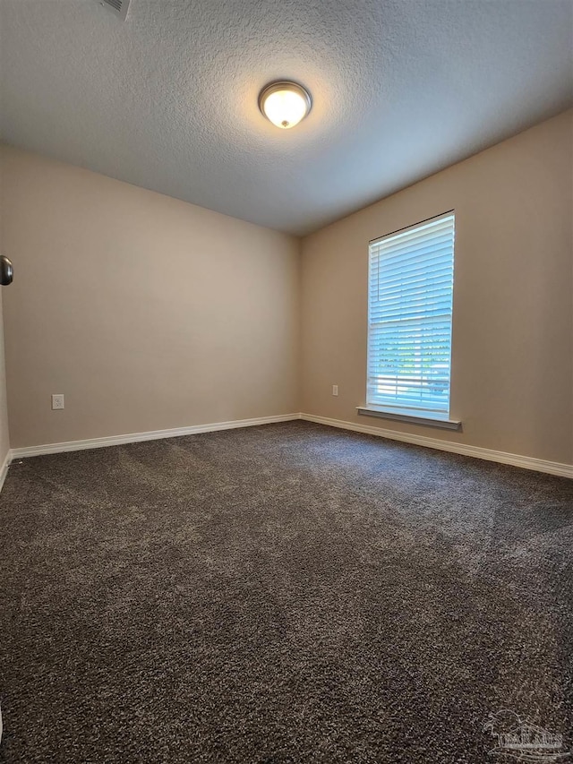 carpeted spare room with a textured ceiling