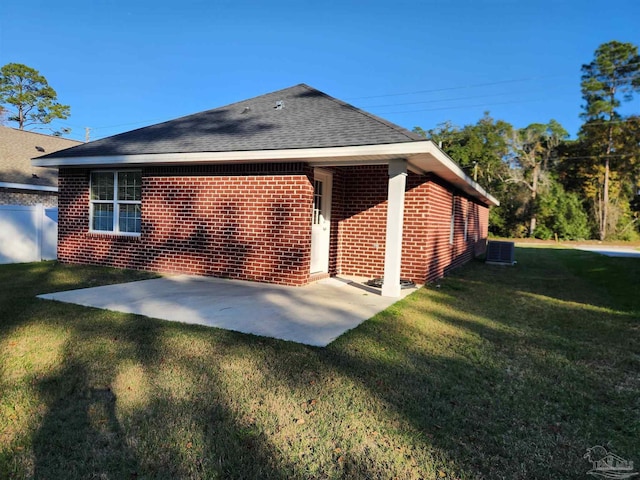 rear view of house featuring cooling unit, a patio area, and a yard