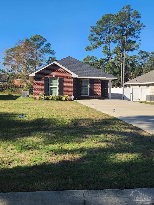 ranch-style home featuring central AC unit and a front yard