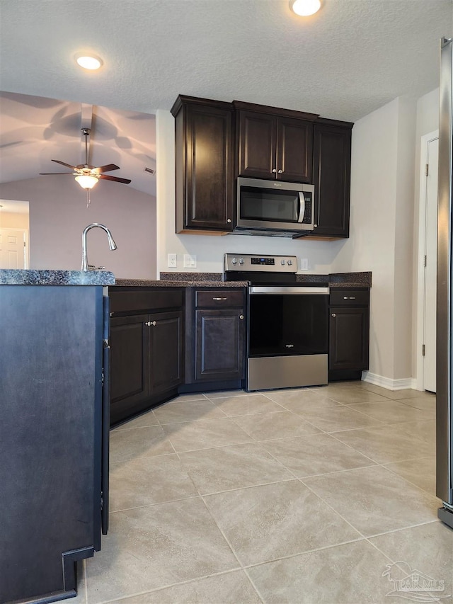 kitchen featuring lofted ceiling, ceiling fan, a textured ceiling, appliances with stainless steel finishes, and dark brown cabinets