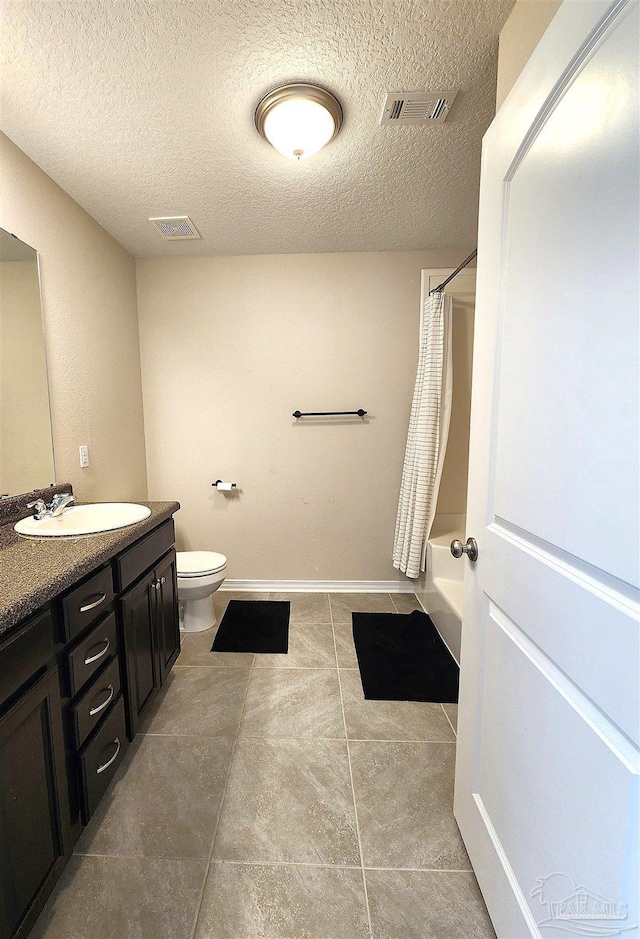 full bathroom with tile patterned floors, vanity, a textured ceiling, shower / tub combo with curtain, and toilet