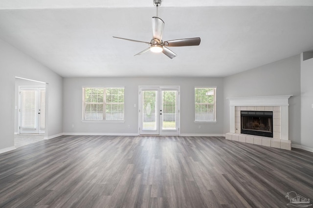 unfurnished living room with baseboards, dark wood finished floors, and a tile fireplace