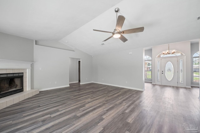 unfurnished living room featuring lofted ceiling, dark wood-style flooring, a tile fireplace, and baseboards