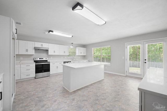 kitchen with a kitchen island, appliances with stainless steel finishes, light countertops, under cabinet range hood, and white cabinetry