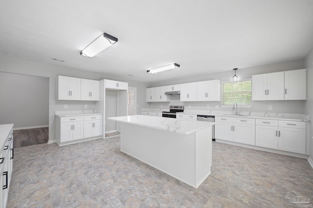 kitchen with under cabinet range hood, stainless steel appliances, a sink, white cabinetry, and a center island