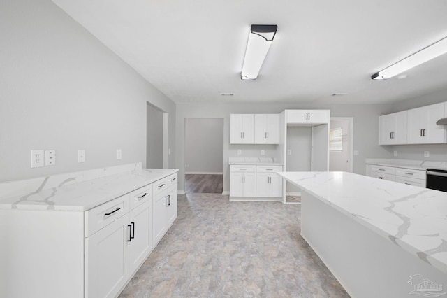 kitchen with light stone countertops and white cabinets