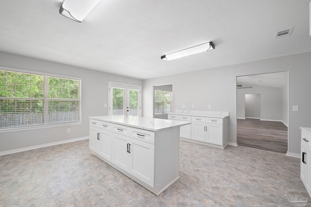 kitchen with french doors, white cabinets, visible vents, and baseboards