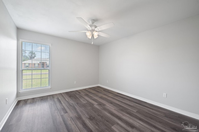 spare room with dark wood finished floors, baseboards, and ceiling fan