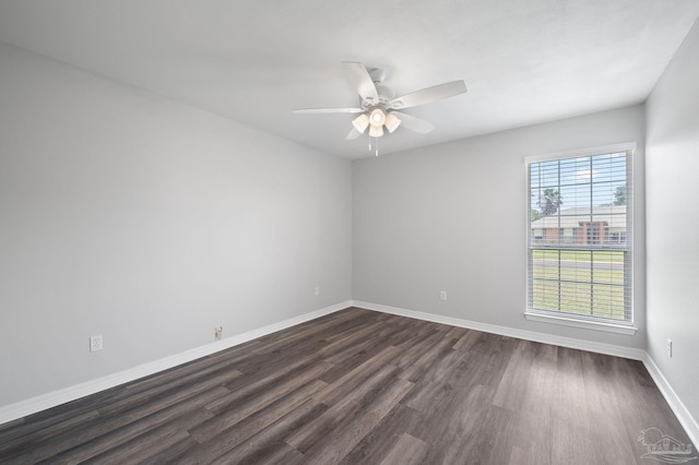 spare room featuring ceiling fan, dark wood-style flooring, and baseboards