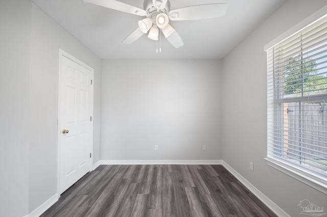 empty room featuring a ceiling fan, baseboards, and dark wood-style flooring