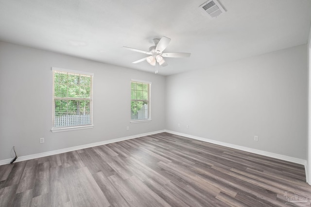 unfurnished room with visible vents, ceiling fan, baseboards, and wood finished floors