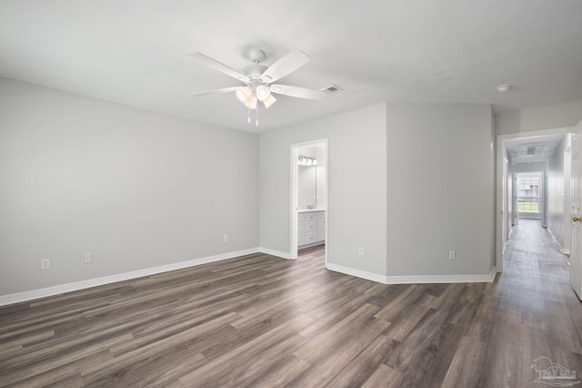 unfurnished room featuring a ceiling fan, dark wood-style flooring, visible vents, and baseboards