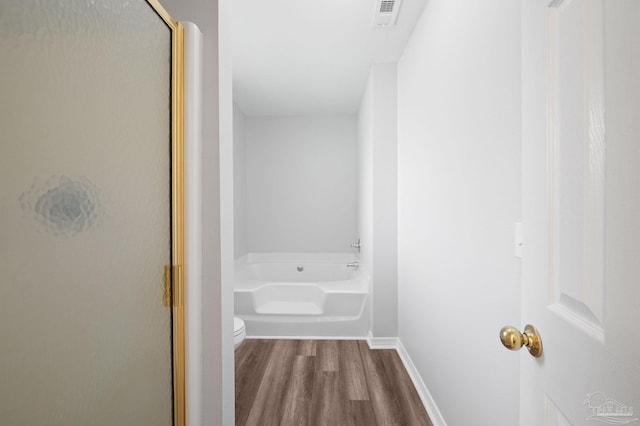 bathroom with wood finished floors, visible vents, baseboards, a shower stall, and a bath