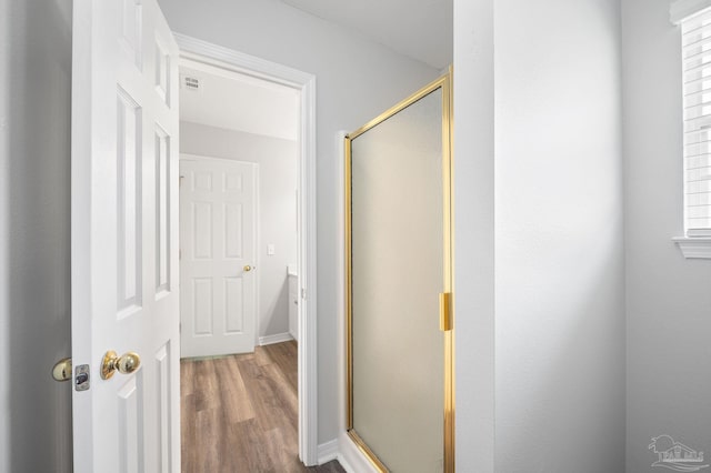 full bathroom featuring a stall shower, visible vents, and wood finished floors