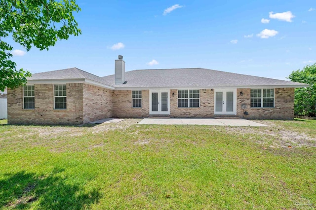 rear view of house featuring french doors, a chimney, a patio area, and brick siding