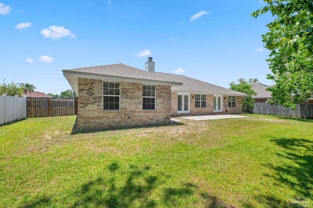 rear view of property with a yard, a fenced backyard, and brick siding