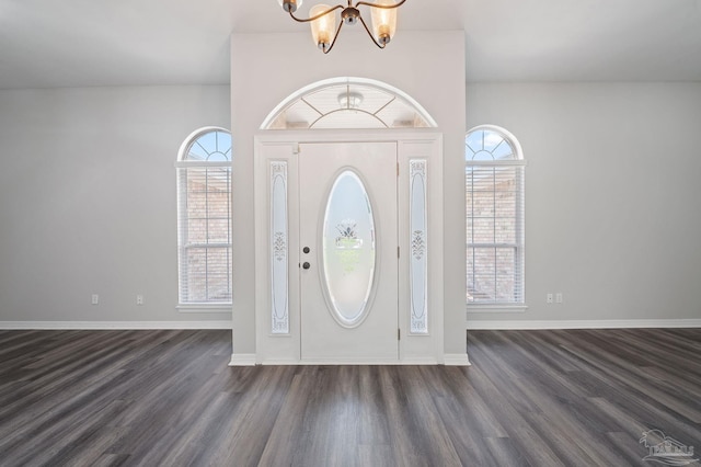 foyer with dark wood-style floors, baseboards, and an inviting chandelier