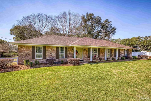 single story home with a front yard, brick siding, and fence