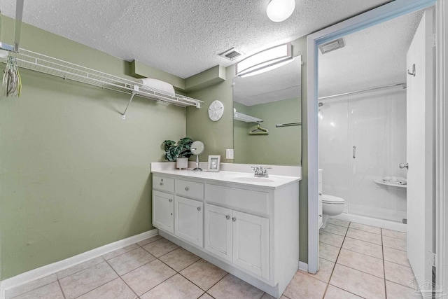 bathroom featuring vanity, a shower, tile patterned flooring, and toilet