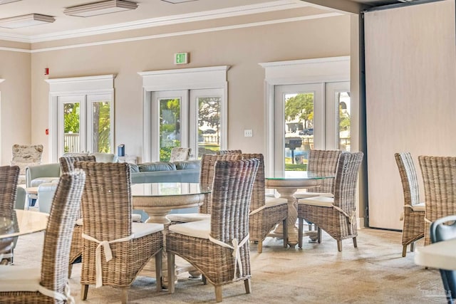 dining area featuring ornamental molding, light carpet, and french doors