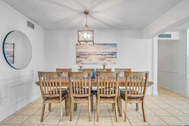 tiled dining room featuring a notable chandelier, crown molding, and a textured ceiling