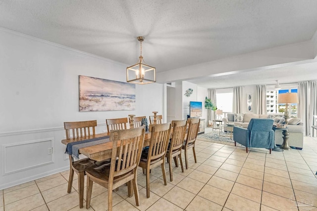 900 Gulf Shore Dr Unit 2051, Destin, FL 32541 - dining room featuring a textured ceiling, light tile patterned flooring, wainscoting, an inviting chandelier, and ornamental molding