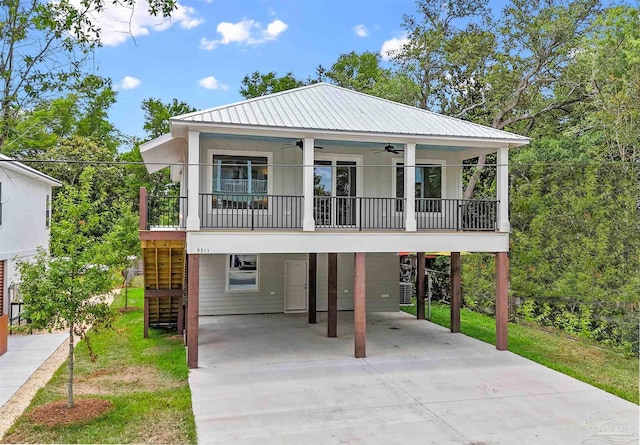 raised beach house featuring a balcony, a front yard, and a carport