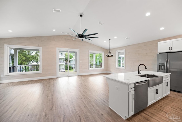 kitchen with light hardwood / wood-style flooring, appliances with stainless steel finishes, sink, lofted ceiling, and ceiling fan