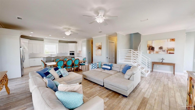 living room with light wood-type flooring, ceiling fan, and crown molding