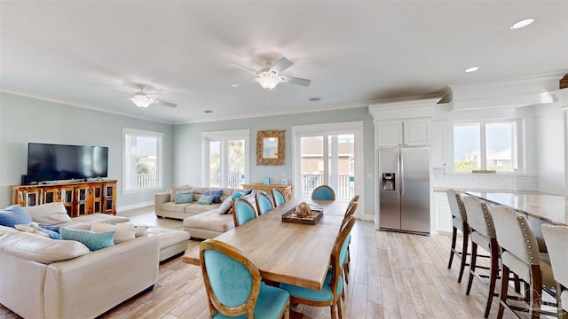 living room featuring ornamental molding, a wealth of natural light, and light hardwood / wood-style flooring