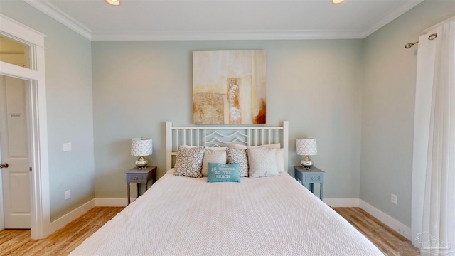 bedroom with ornamental molding and light hardwood / wood-style flooring