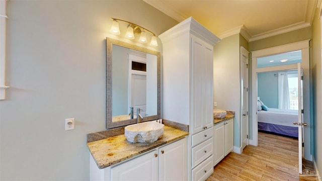 bathroom featuring hardwood / wood-style floors, vanity, and ornamental molding