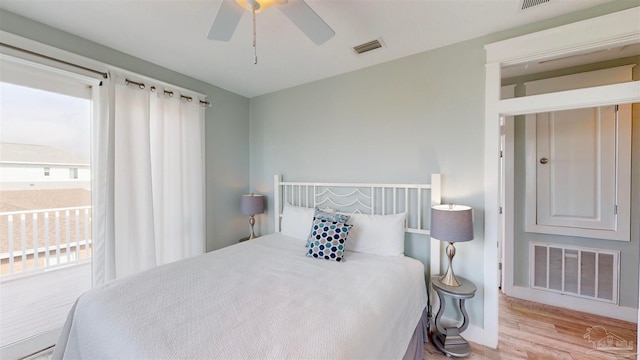 bedroom featuring light hardwood / wood-style floors, ceiling fan, and ensuite bathroom