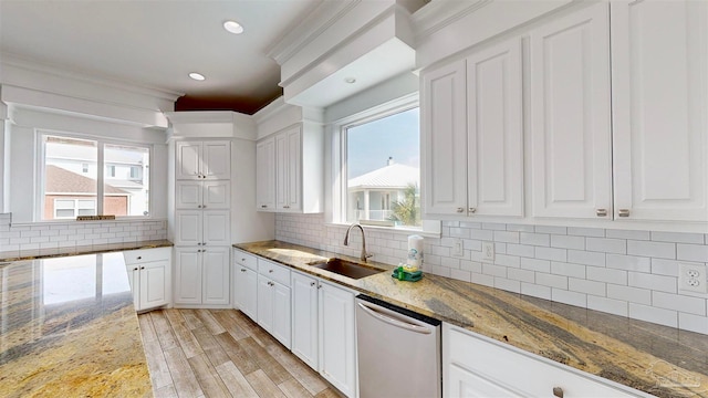 kitchen with stone countertops, dishwasher, white cabinetry, and light wood-type flooring