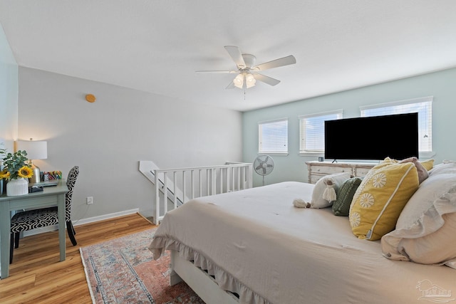 bedroom with light wood-style flooring, baseboards, and ceiling fan