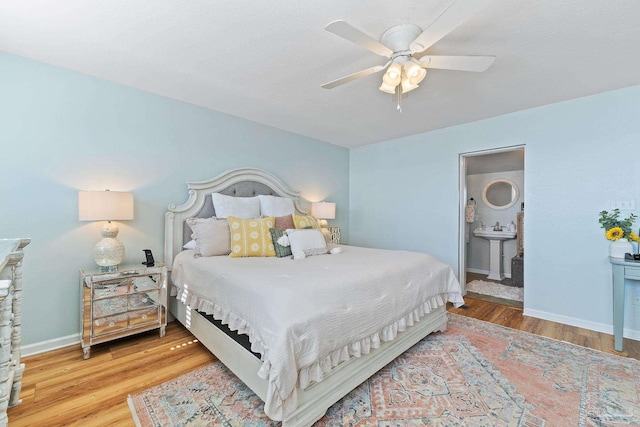 bedroom featuring a ceiling fan, wood finished floors, connected bathroom, and baseboards