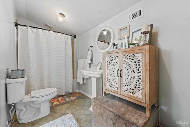 bathroom featuring visible vents, a shower with shower curtain, toilet, lofted ceiling, and tile patterned floors