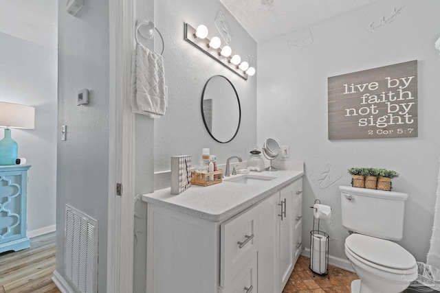 bathroom featuring baseboards, visible vents, vanity, and toilet