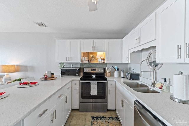 kitchen featuring visible vents, appliances with stainless steel finishes, white cabinets, a sink, and a textured ceiling